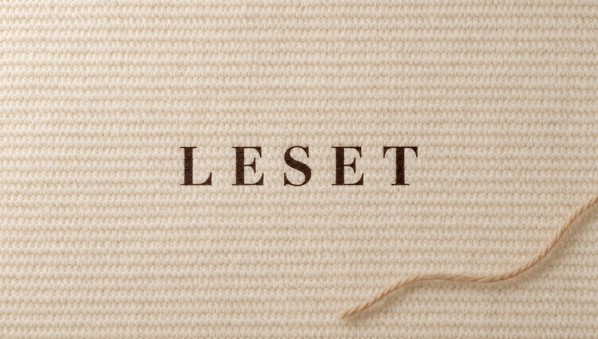 The LESET name printed on cream knit