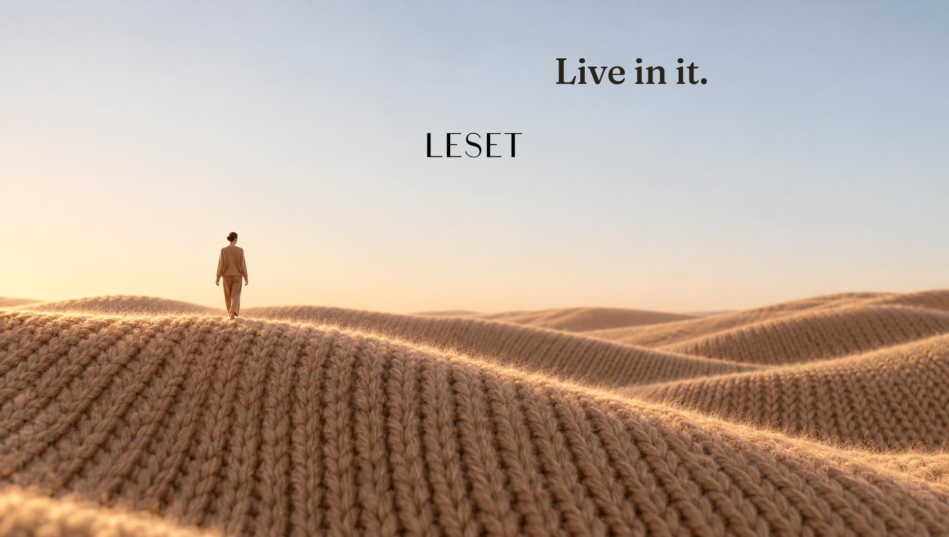 A tiny woman walking across dunes made of knit
